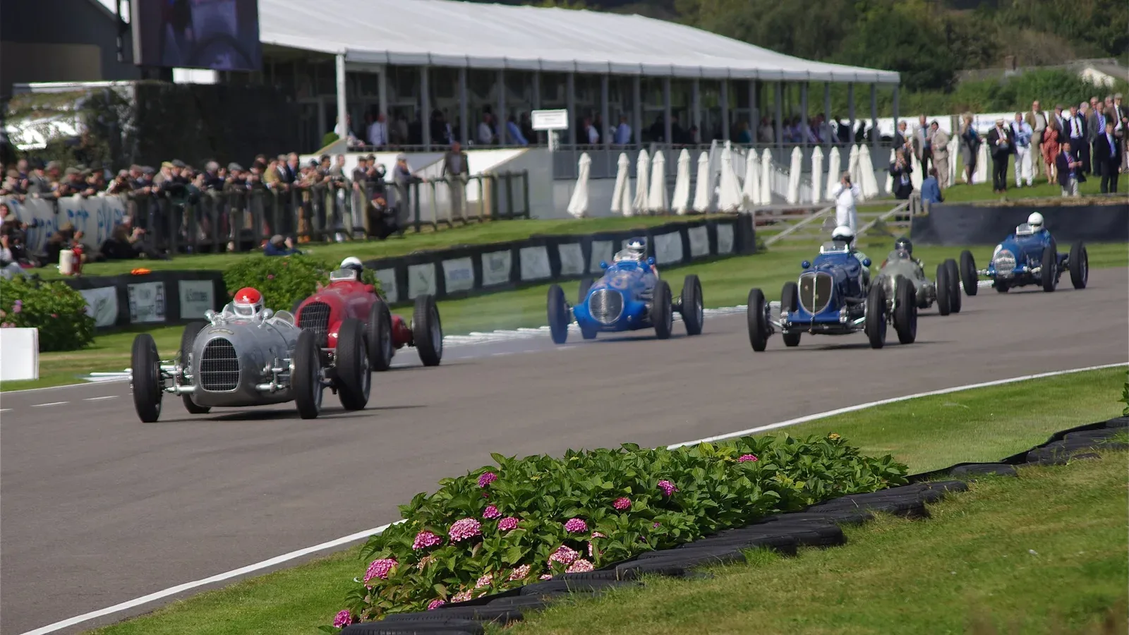Historic racing cars competing on the circuit at Goodwood Revival in 2012