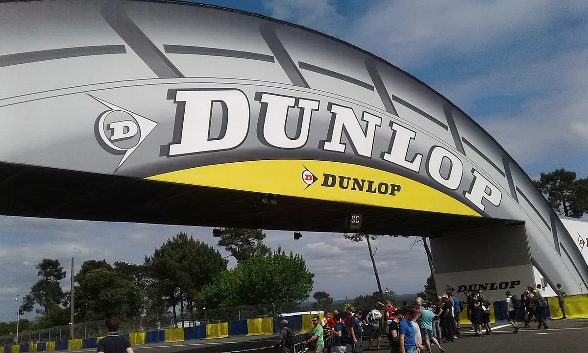 Spectators walking beneath the tyre-shaped footbridge over the circuit