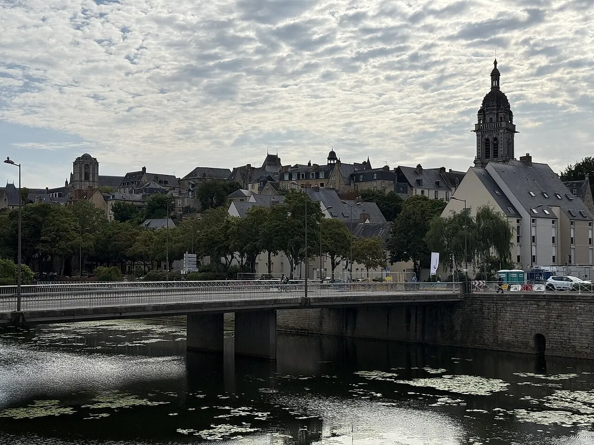 Le Mans old town rooftops and a domed bell tower above the river Sarthe and a bridge
