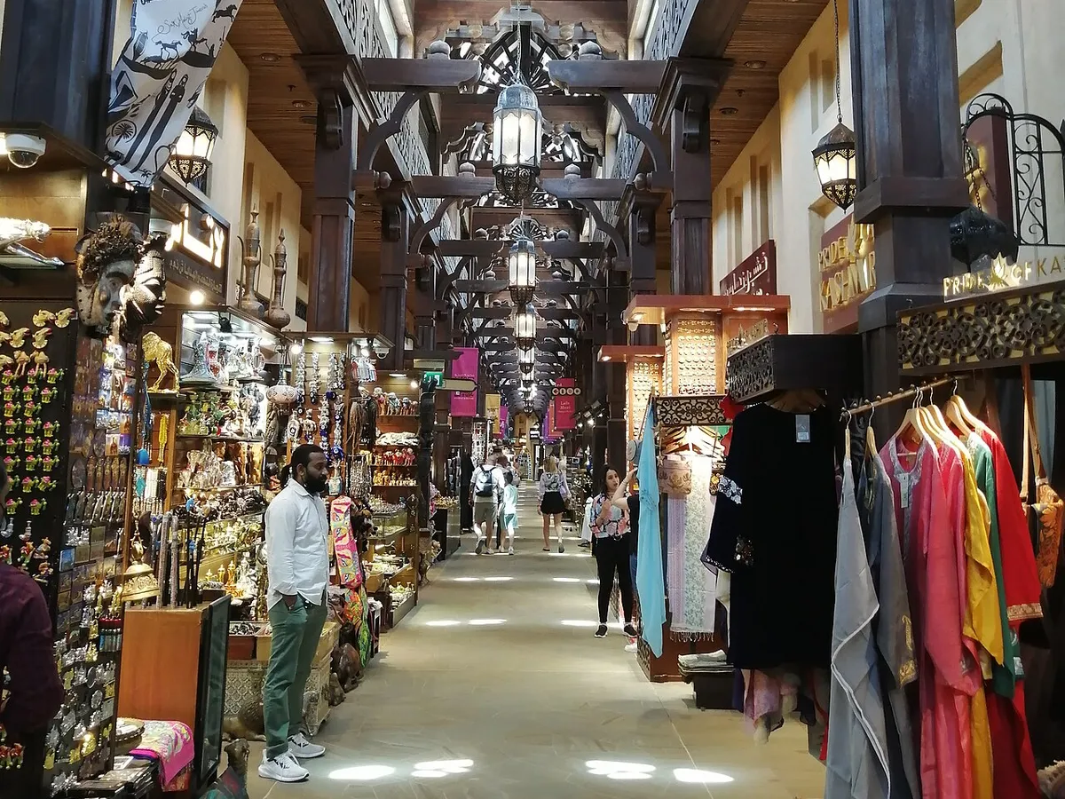 The lantern-lit wooden ceiling and shopfronts of a covered passage in Souk Madinat Jumeirah