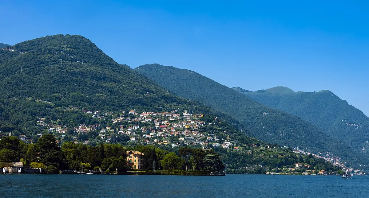 Cernobbio's lakeside villas and wooded hills seen from a ferry on Lake Como