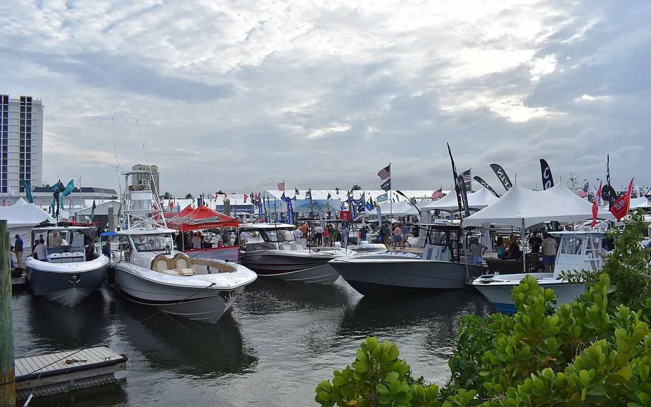 Rows of centre-console boats moored at the docks under show tents and flags