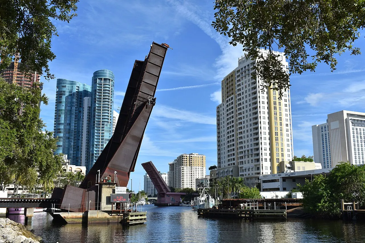 Two raised drawbridges on the New River with downtown Fort Lauderdale towers behind