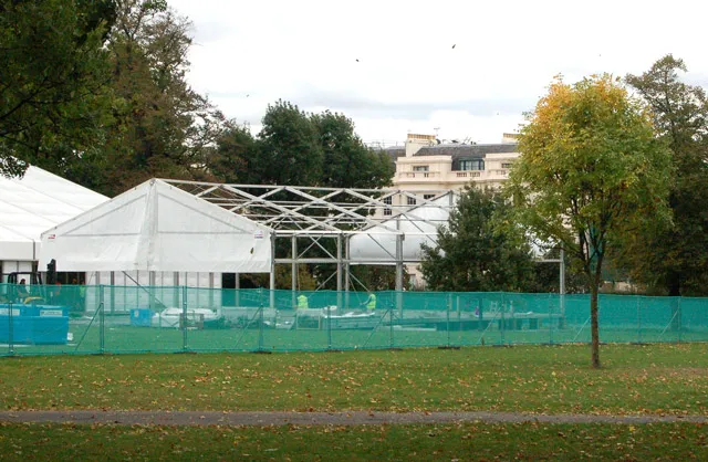 White marquees of the Frieze Art Fair being built behind fencing in Regent's Park