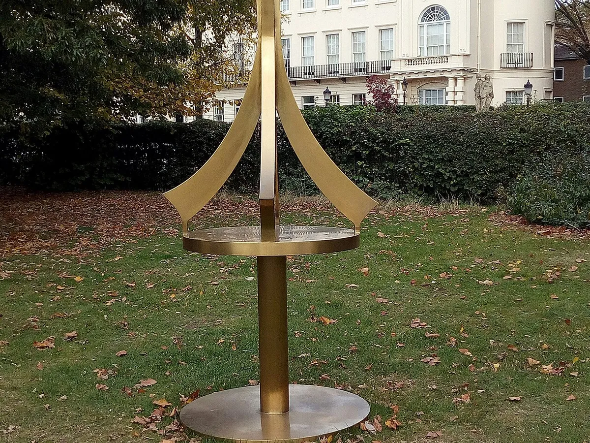 A tall gold sculpture in front of a cream Regency terrace beside Regent's Park