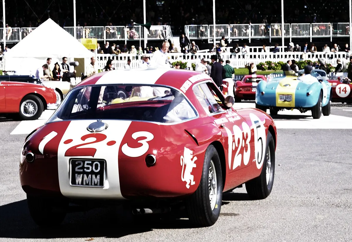 A red 1953 Ferrari 250 MM with racing number 23 in front of crowds at Goodwood
