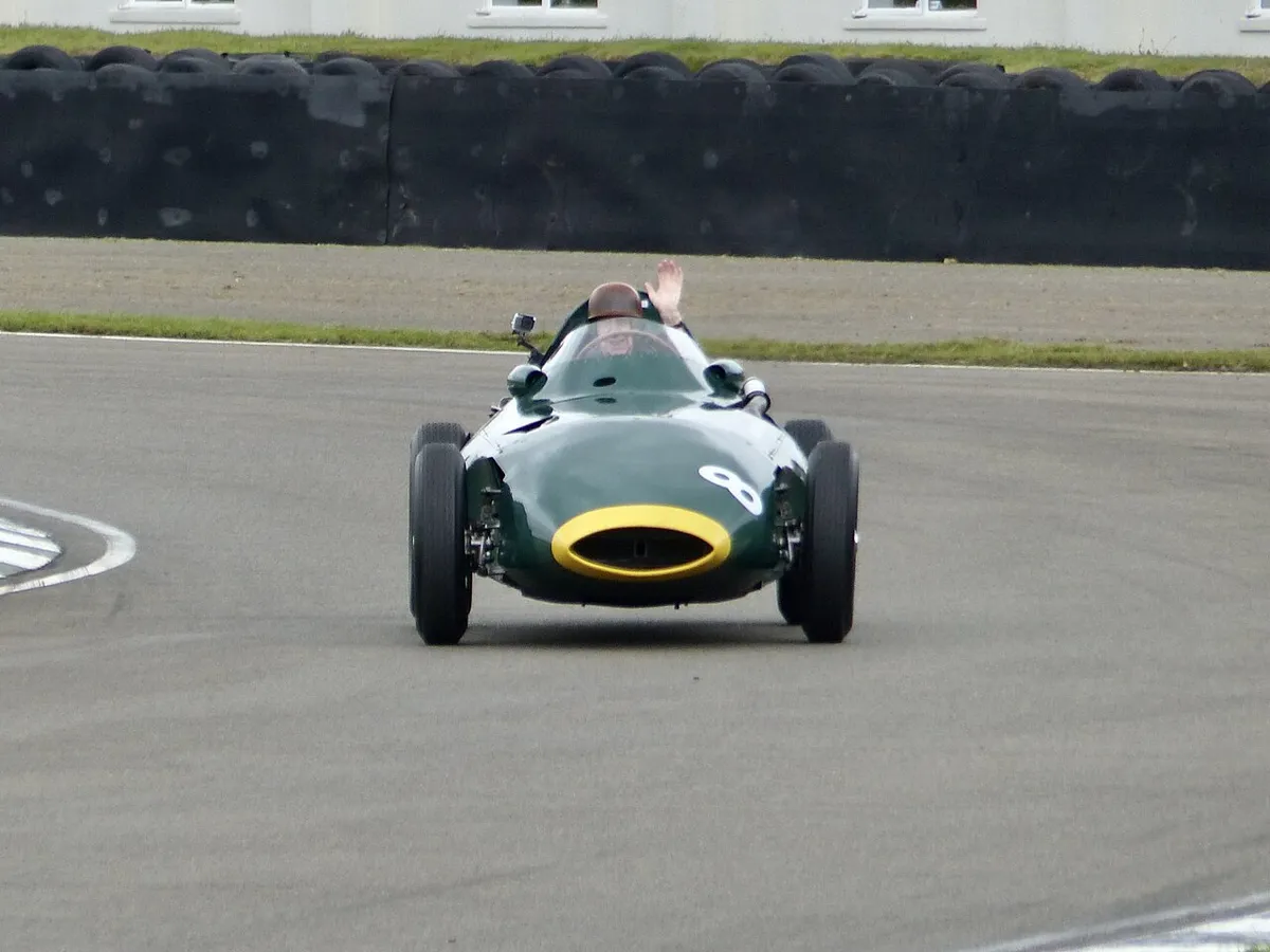 Tony Brooks driving a green Vanwall Formula 1 car around a corner at Goodwood