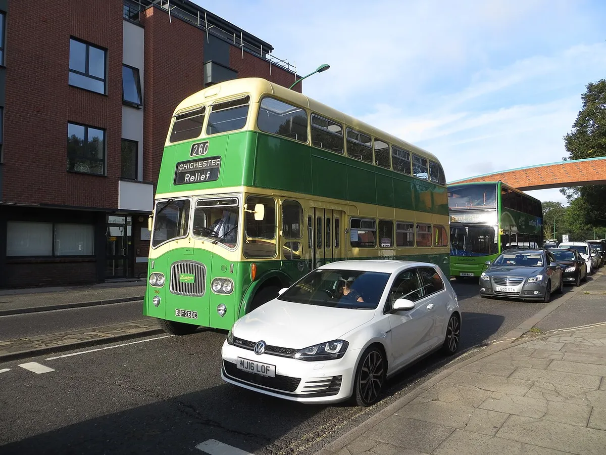 A green and cream vintage double-decker bus on a Chichester street on Revival day
