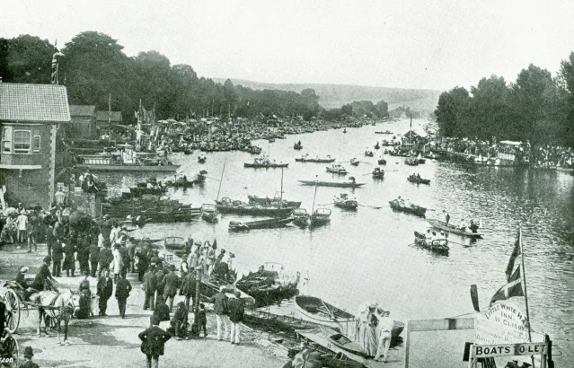 A black-and-white photograph of crowds and boats crowding the river at the Henley finish line