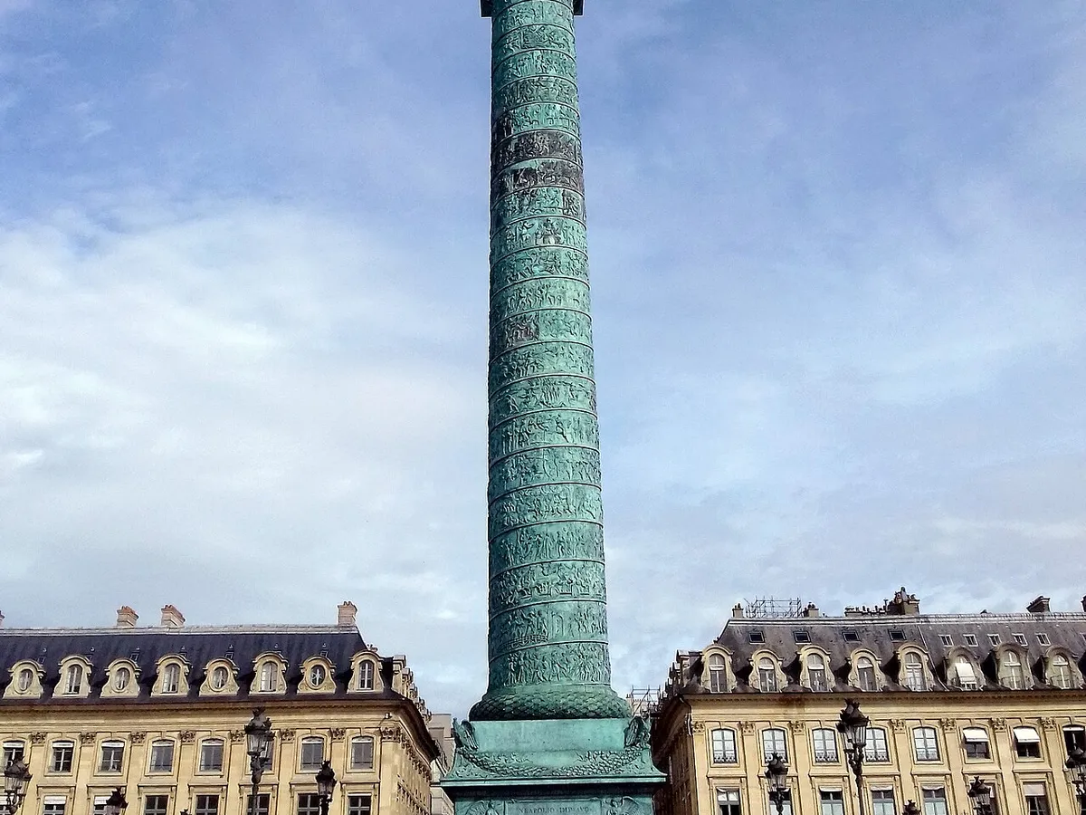 The green bronze Vendôme Column rising above the stone facades of Place Vendôme