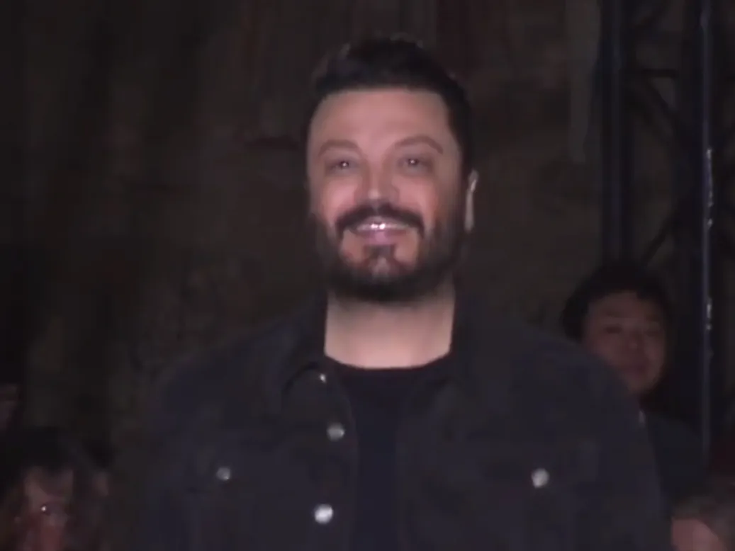 The designer Zuhair Murad smiling as he takes his bow at the end of a show