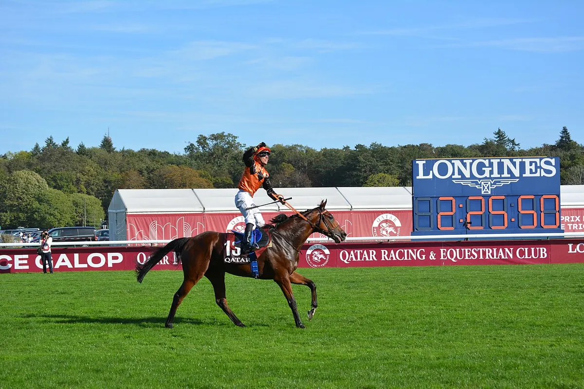 Ace Impact and his jockey in orange silks returning past the Longines clock after winning the Arc