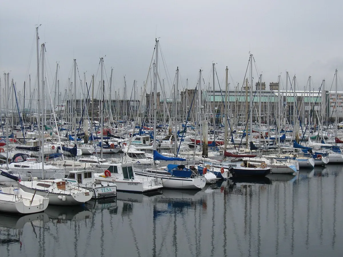 Rows of yachts with tall masts moored at the pontoons of Cherbourg marina