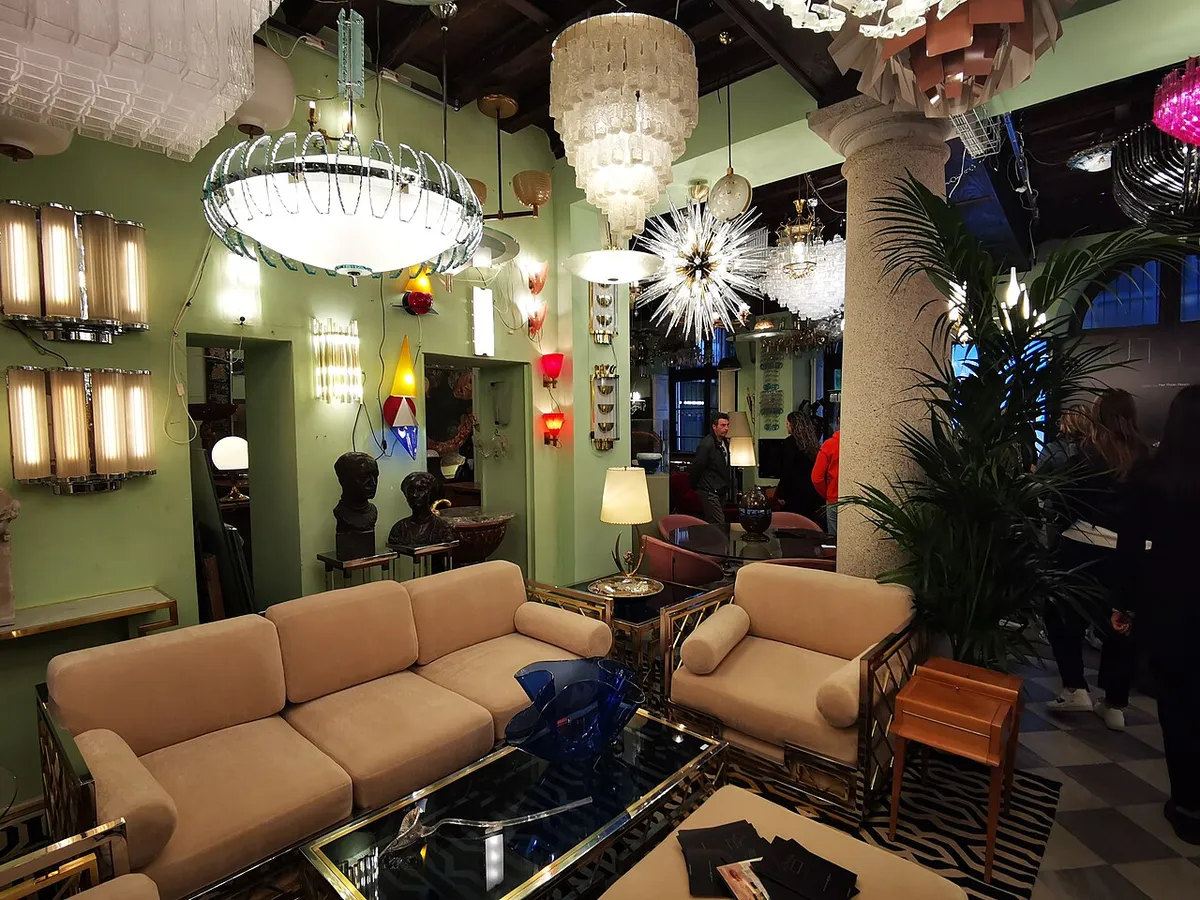 A Brera venue dressed with chandeliers, sofas and plants for a Fuorisalone design installation