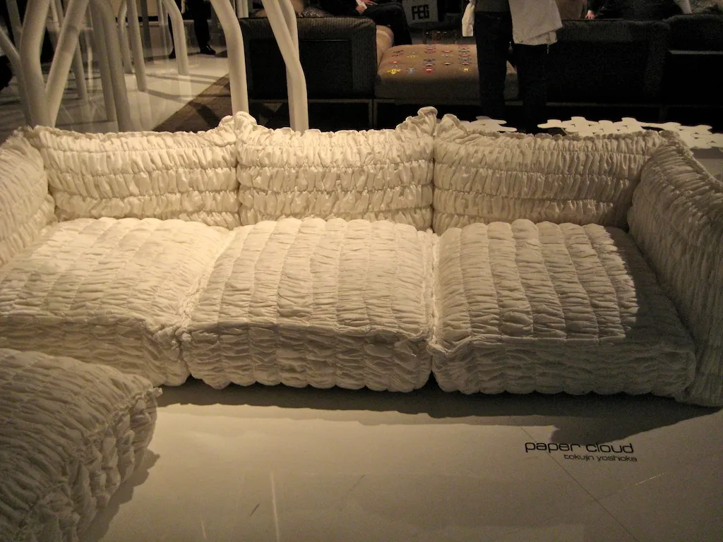 A white, softly quilted Paper Cloud sofa on display on a stand at the furniture fair