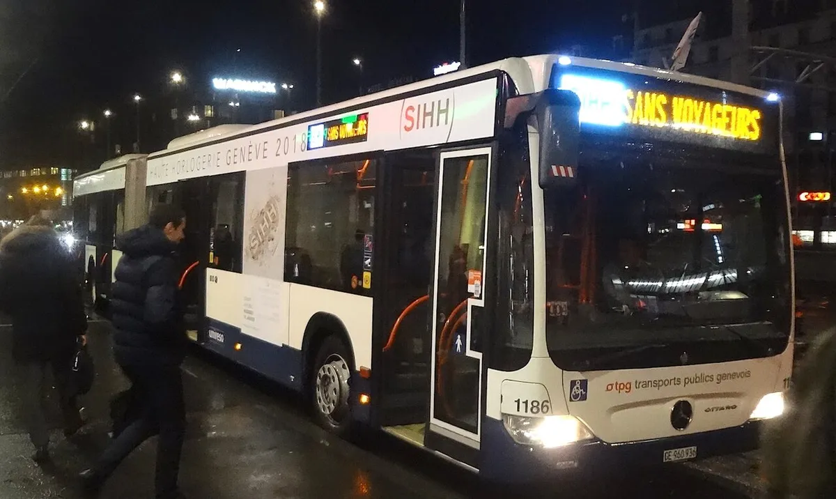 A Geneva public transport bus branded for the SIHH watch salon at Cornavin station at night