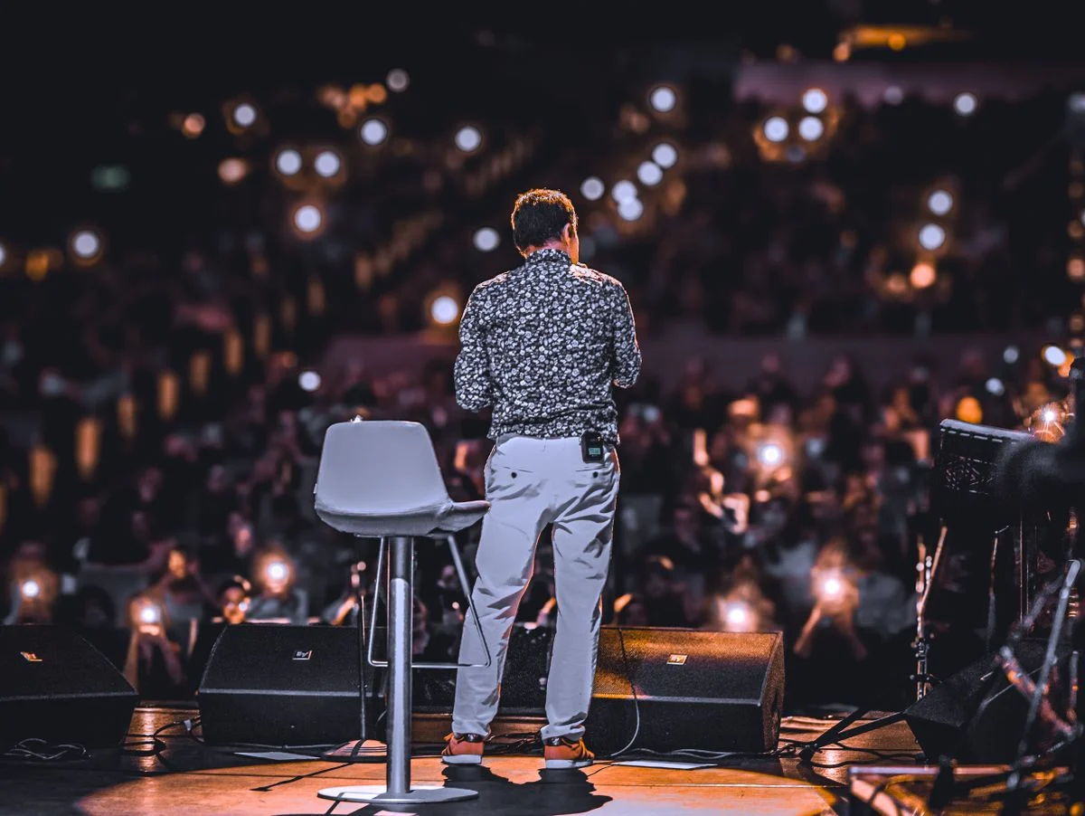 A speaker addresses an audience with phone lights